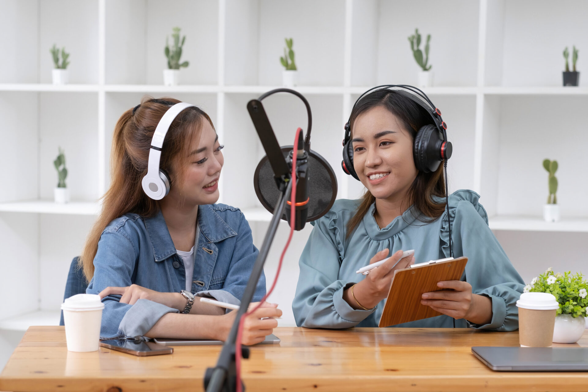 Smile two asian young woman, man radio hosts in headphones, micr